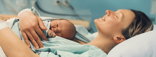 Mum in hospital gown holding newborn