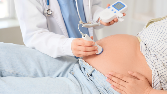 pregnant couple listening to baby heartbeat at home with Doppler