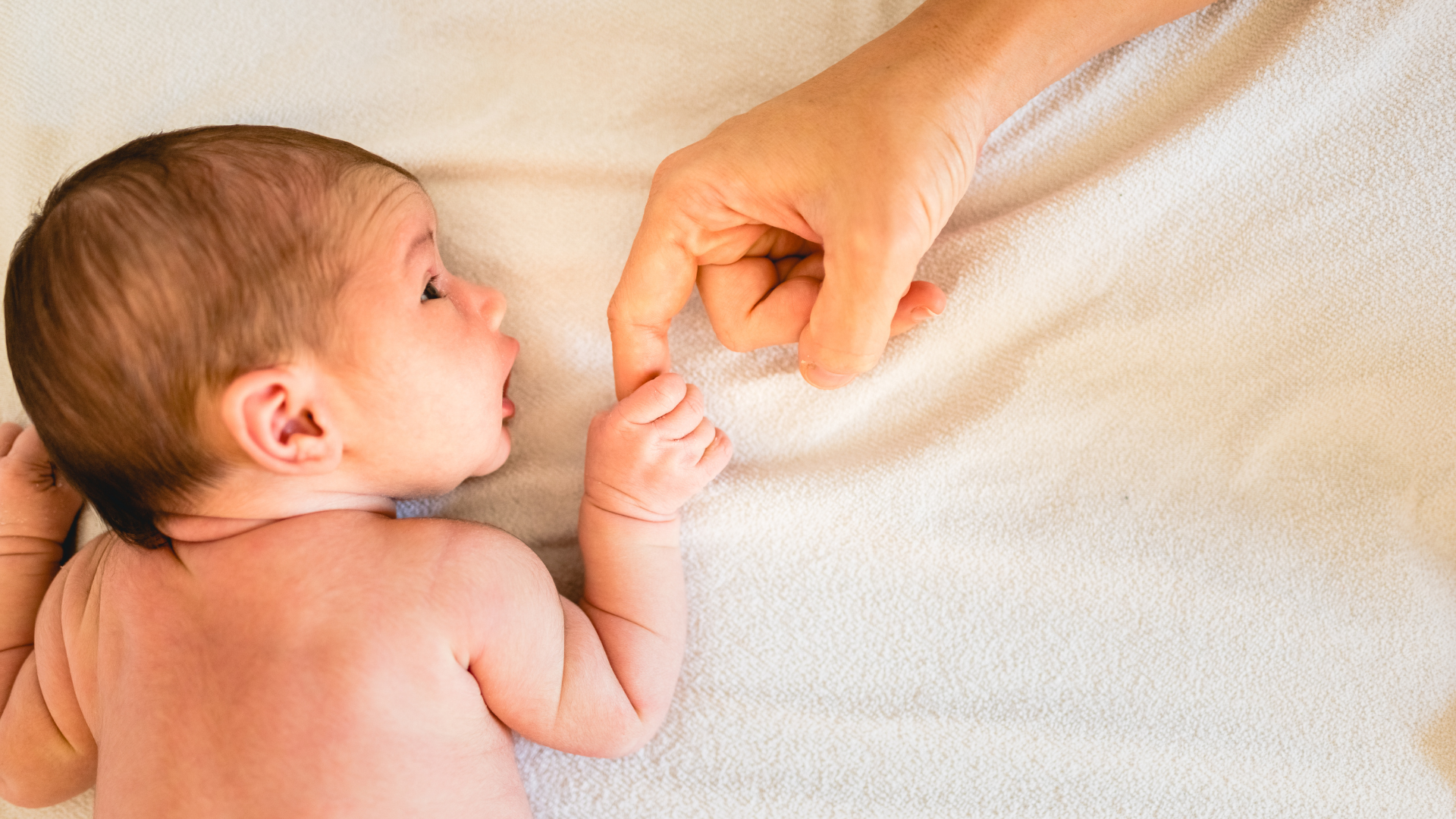 Newborn baby holding his mums hand