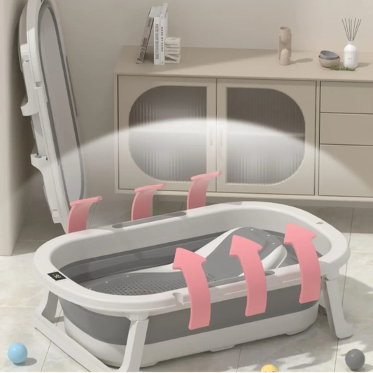 Foldable baby bathtub with pink straps on a light-colored floor.