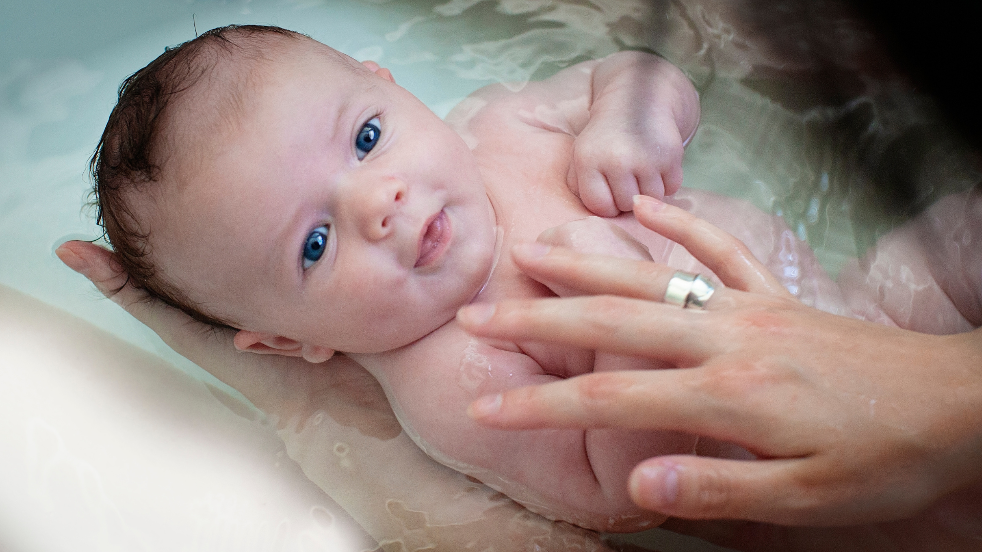Newborn baby being held with a blurred background