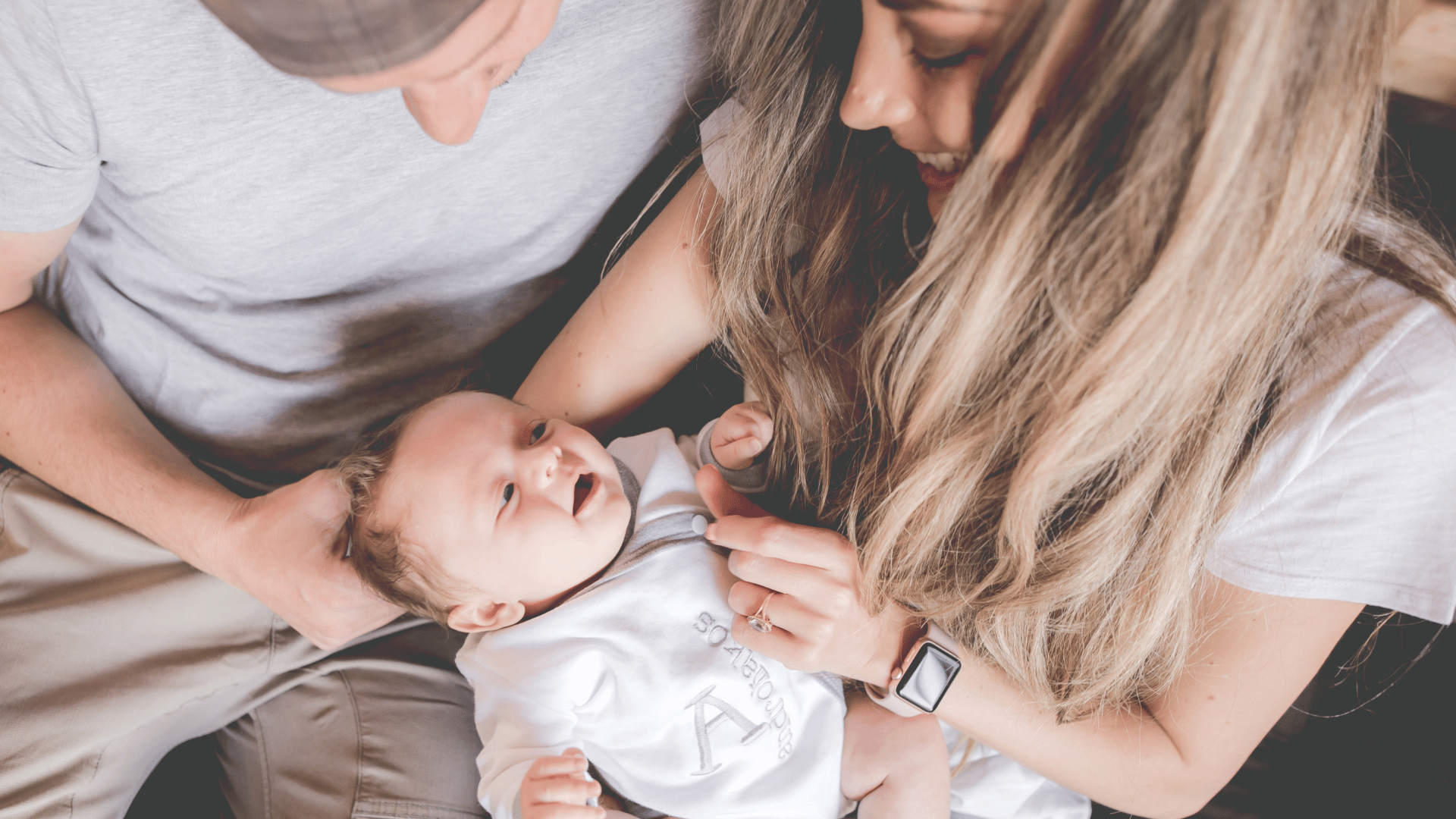 Two adults holding a baby close together