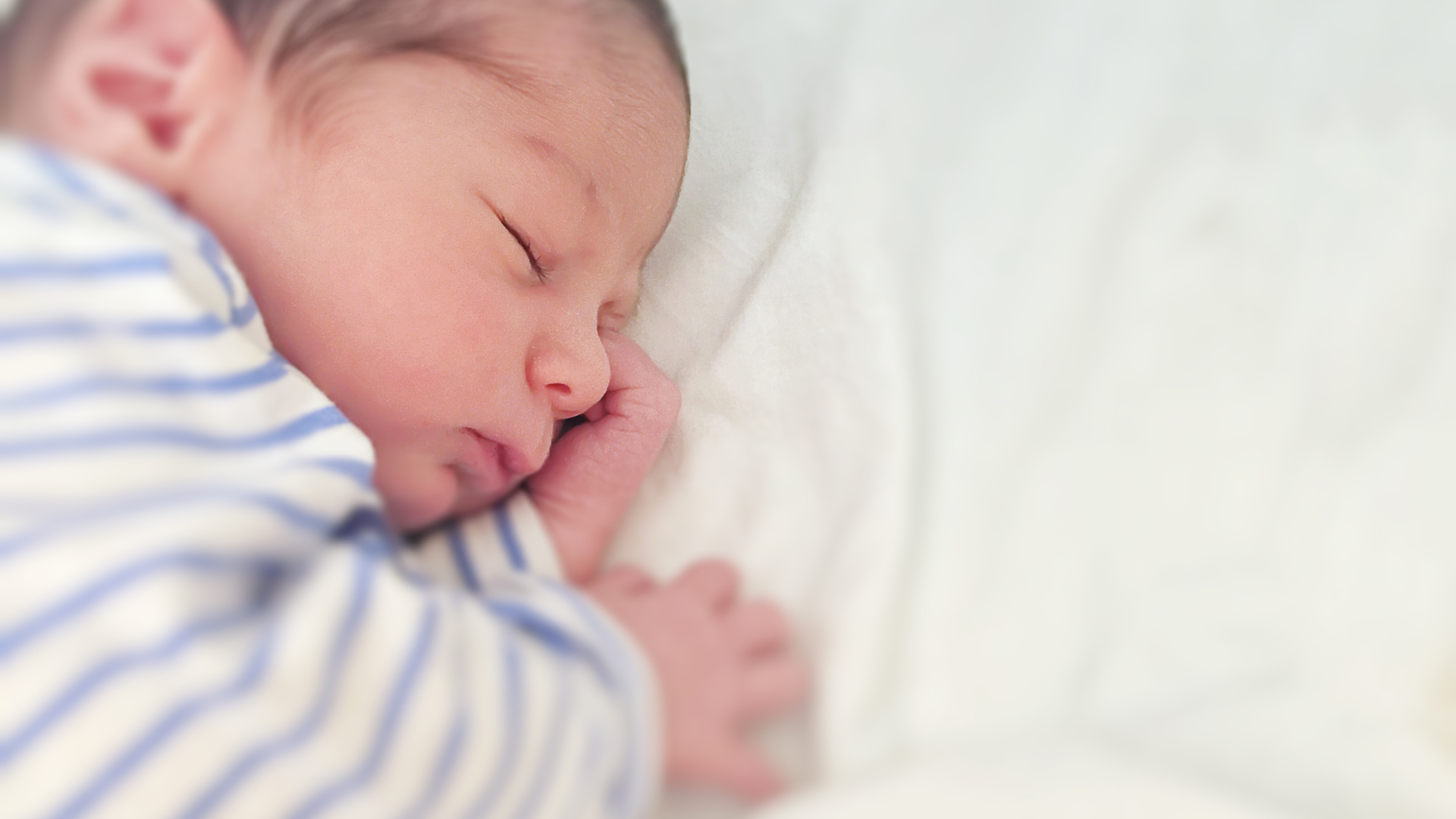 Newborn baby sleeping peacefully with a soft focus background