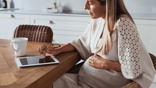 A pregnant woman sitting comfortably on a chair using the support belt