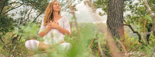 A serene pregnant woman meditating or sitting calmly with a peaceful background.