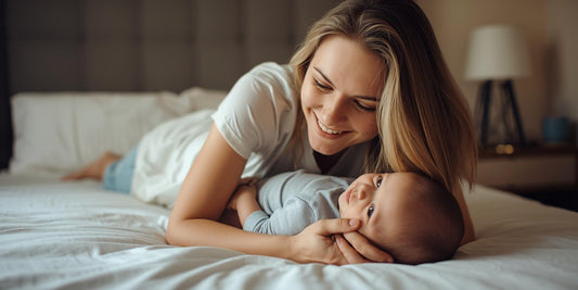 mum lying on bed smiling at baby during tummy time