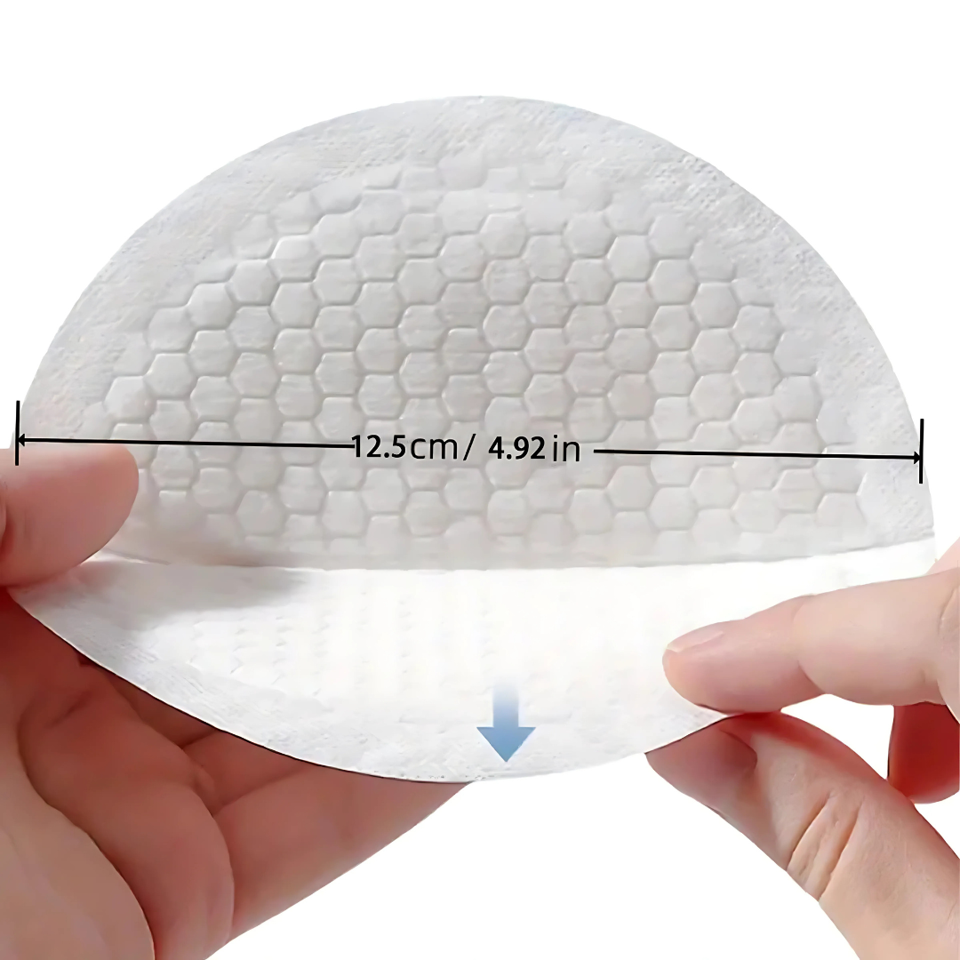 White silicone bra pad held by hands with measurements indicated