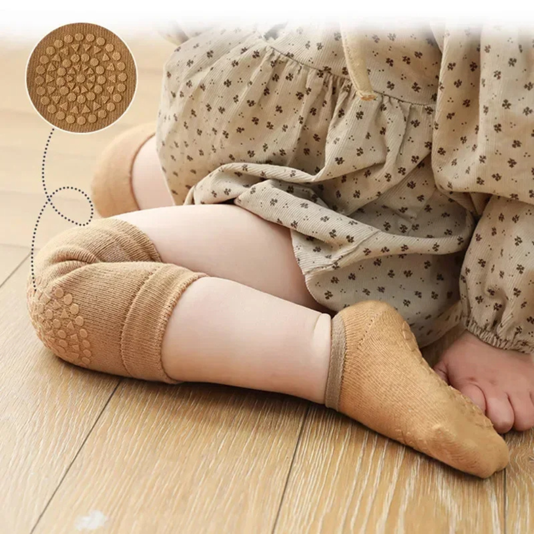 Child wearing beige tights with textured sole on a wooden floor