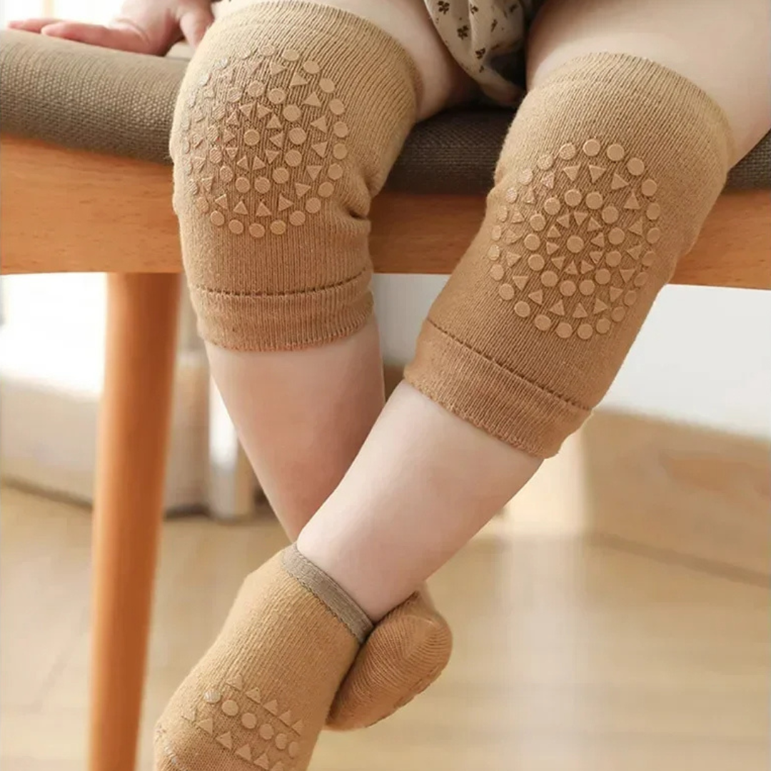 Children's brown knee pads and socks worn by a child sitting on a wooden chair.