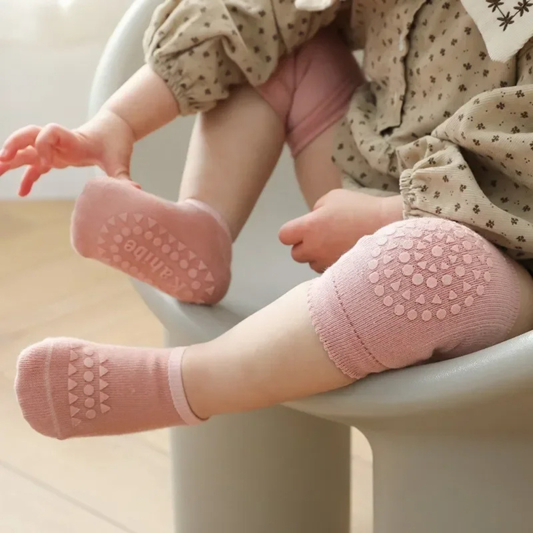 Child wearing pink knee pads and socks sitting on a chair.