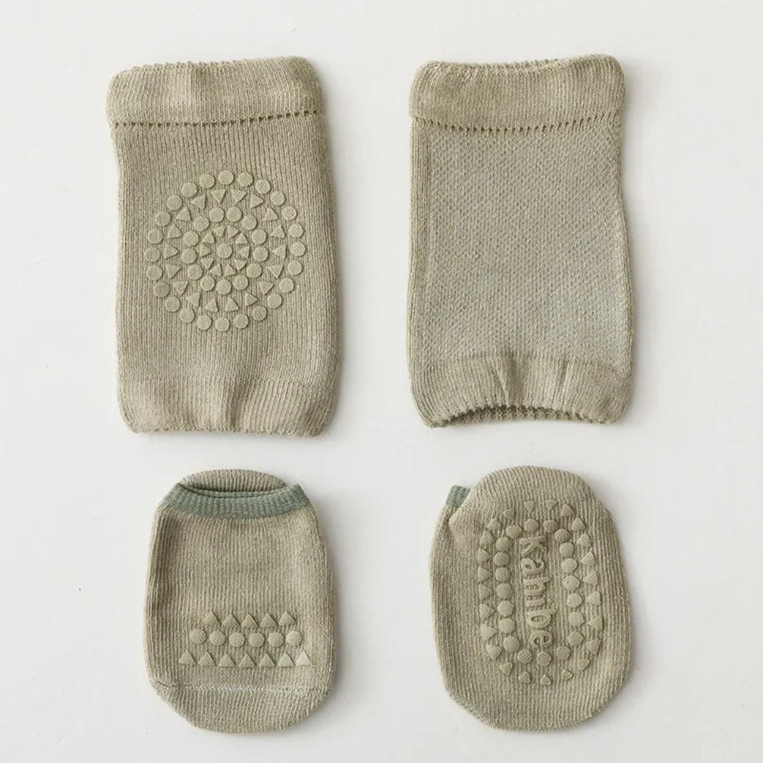 Set of four green baby socks with textured sole on a white background