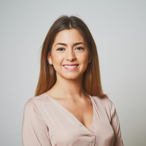 Headshot of a woman smiling wearing a beige blouse