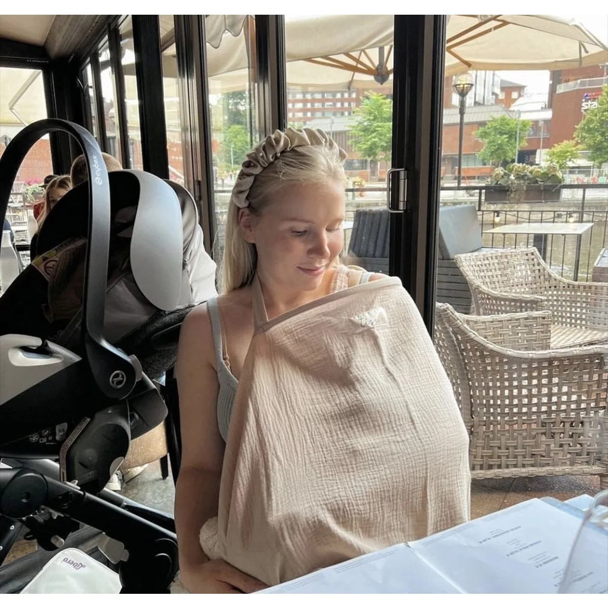 Mother using the nursing cover in a public place