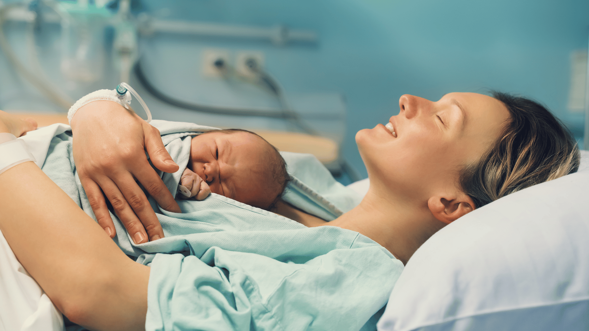 Newborn baby being held by a woman in a hospital setting
