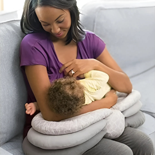 Woman breastfeeding a child using an inflatable nursing pillow on a couch.
