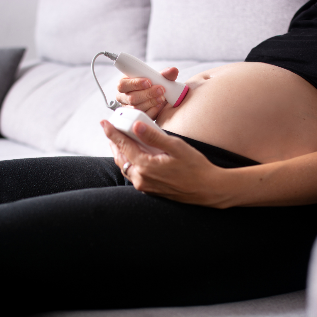 Pregnant woman using a fetal doppler