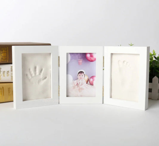White photo frame with baby handprint and footprint on a white surface, with 'Morning Baby Store' text above.