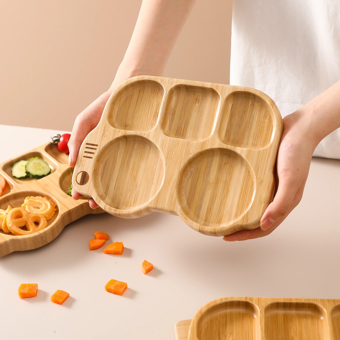 Wooden snack tray with compartments held by a person on a light background